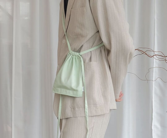 Model wearing a mint green side bag