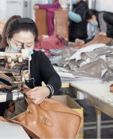 woman attaching zipper to a leather bag