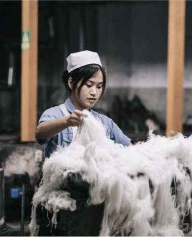 Woman segregating yarns in a fabric manufacturing factory