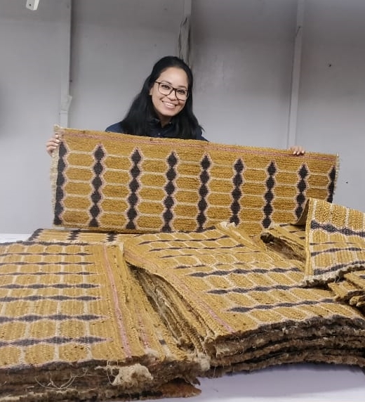 Women holding fabric mat